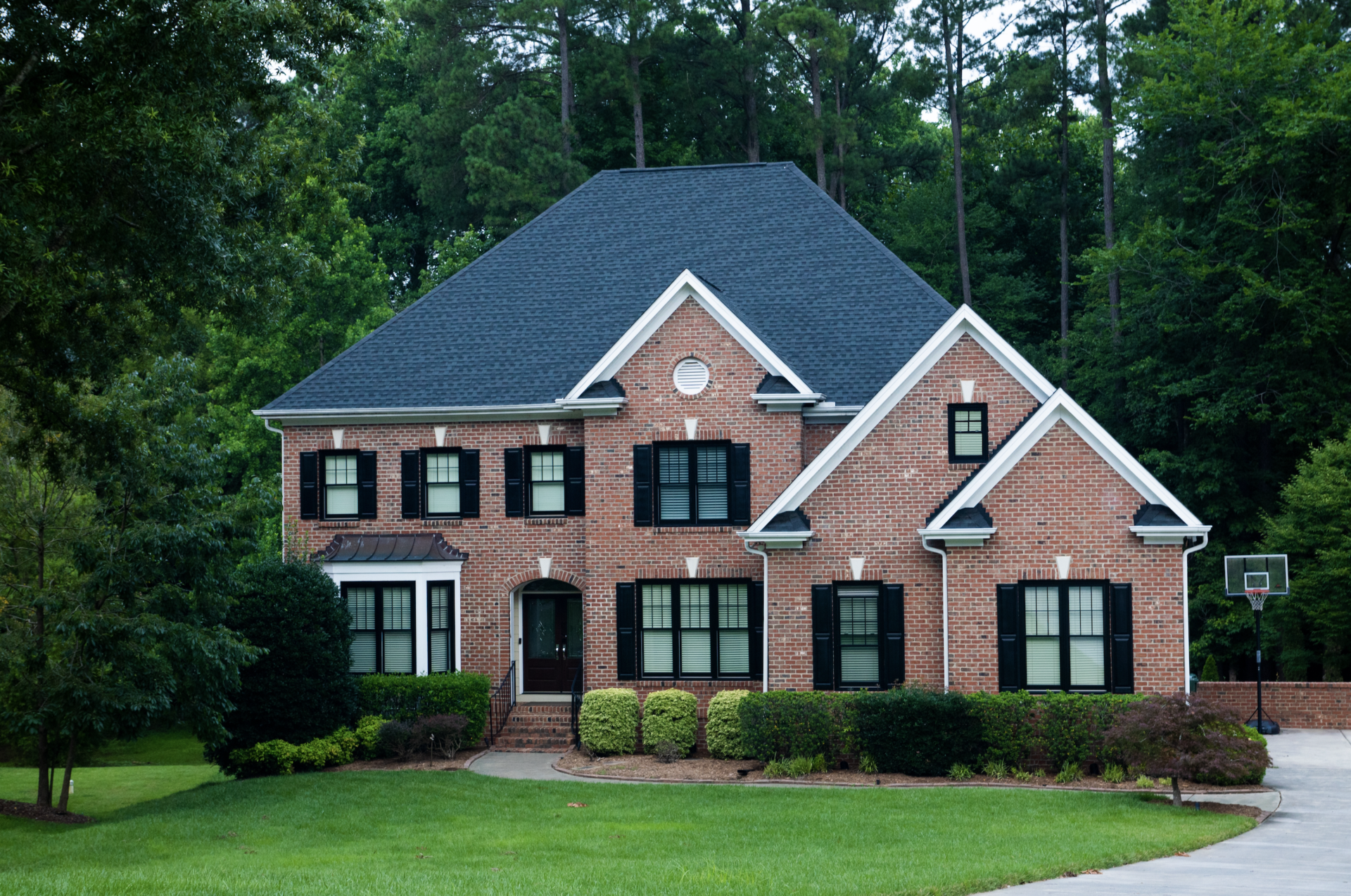 traditional brick home with black windows and black shutters in Cary North Carolina
