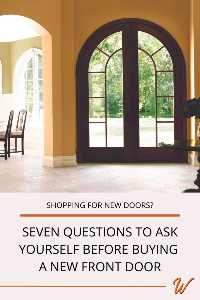 Interior of a home's foyer with a large round top wood front door. Caption reads 
