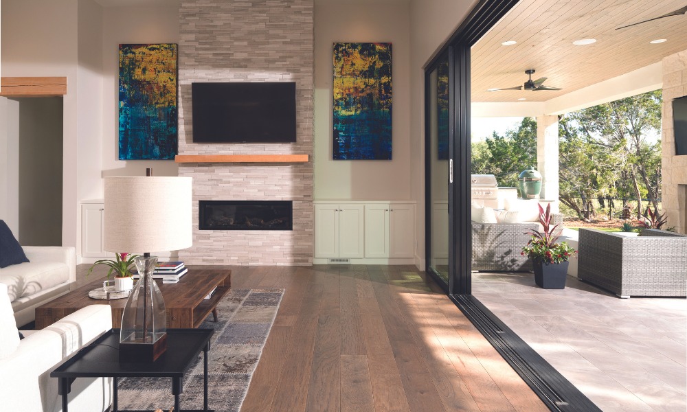 Andersen black multiglide door creates indoor outdoor living space between a living room and a patio