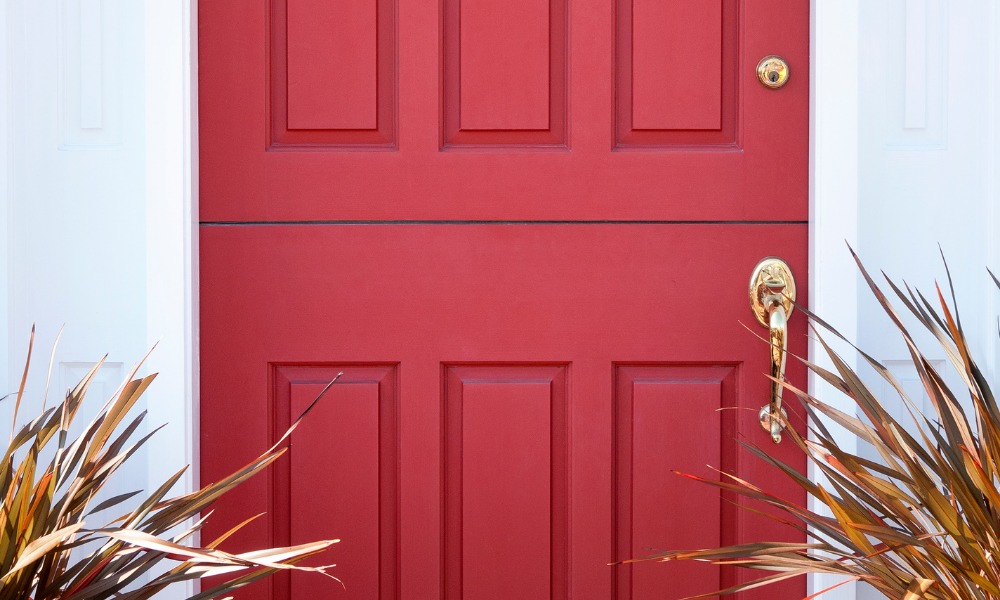 close up of a red Dutch door with brass hardware