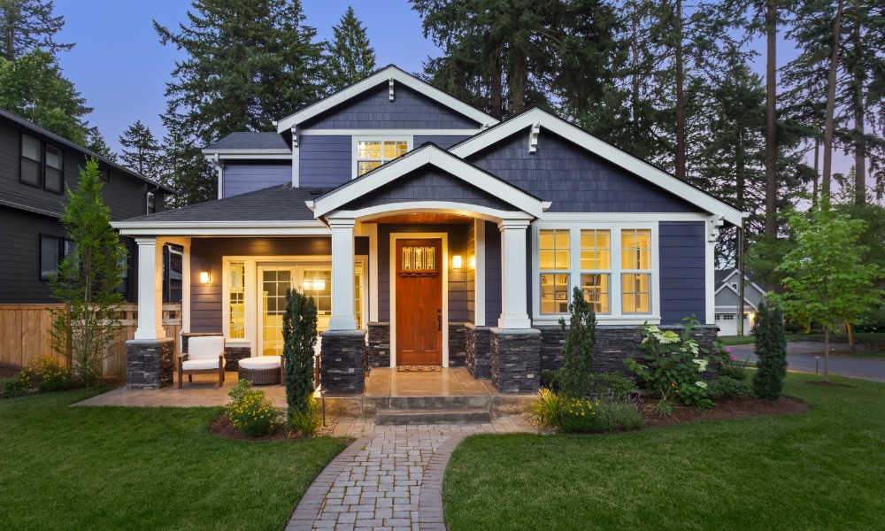 Blue craftsman style home with a wood 1/4 light door with dentil shelf