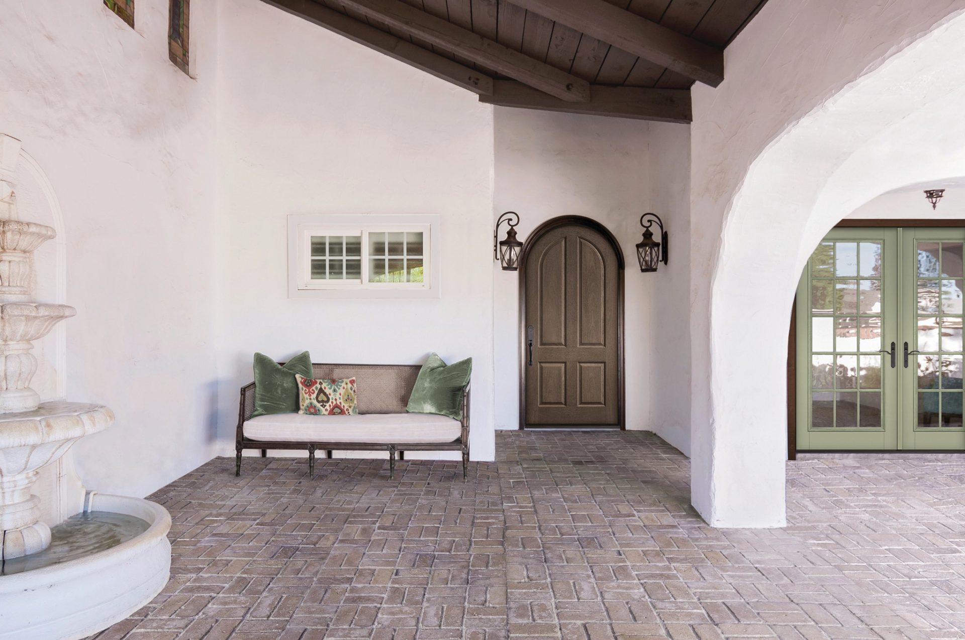 wood round top front door in a Mediterranean style home 