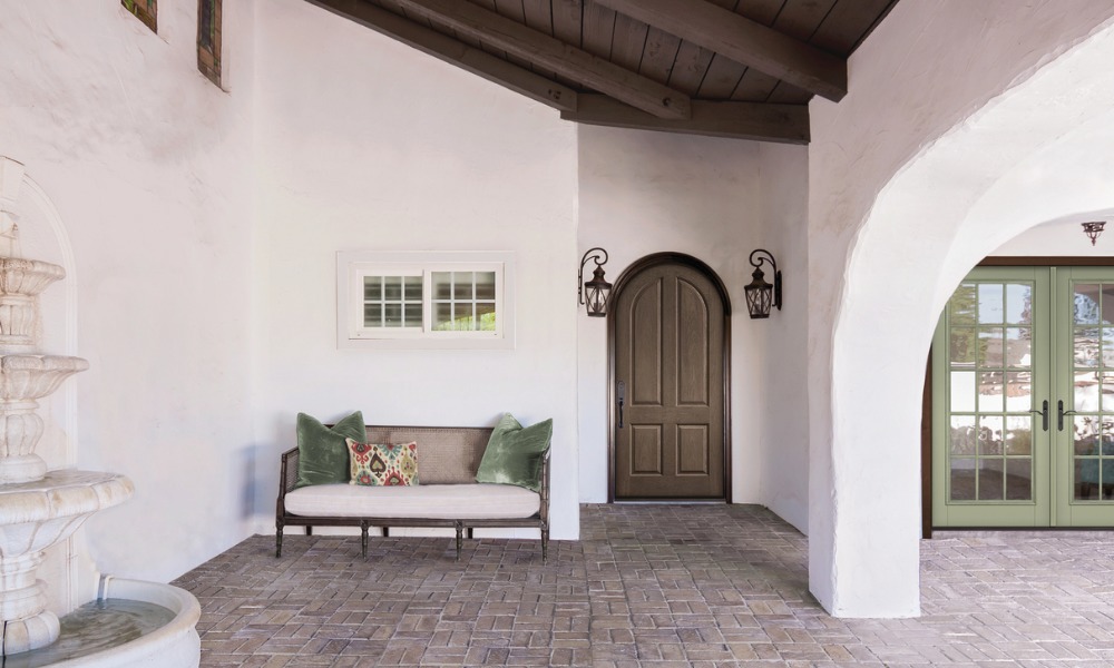 round-top wood front door in a Mediterranean style portico