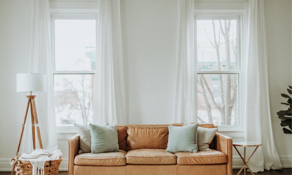 a midcentury modern living room with two white double hung windows