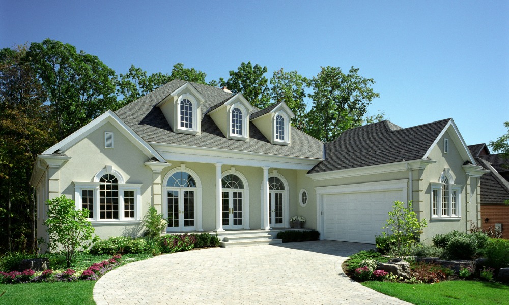 a gray stucco house with white french country windows