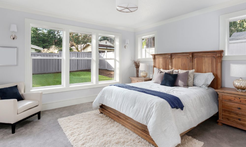 Interior of a bedroom with a triple unit of double hung windows