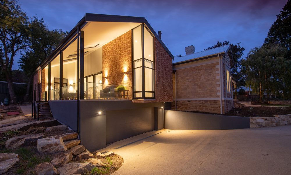 Contemporary home at dusk with large black modern windows.