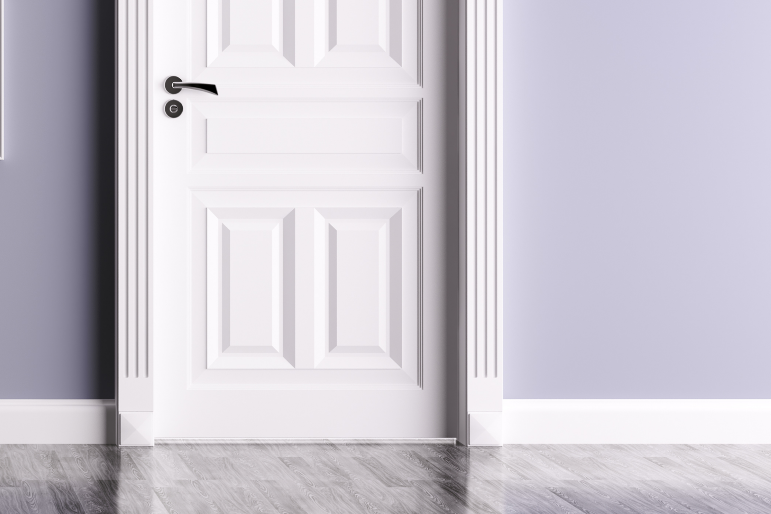A white, paneled door with a black handle is set in a lavender-colored wall with decorative trim and a plinth block—what is a plinth block on a door? It’s the base piece adding style where trim meets the floor's reflective gray wood planks.
