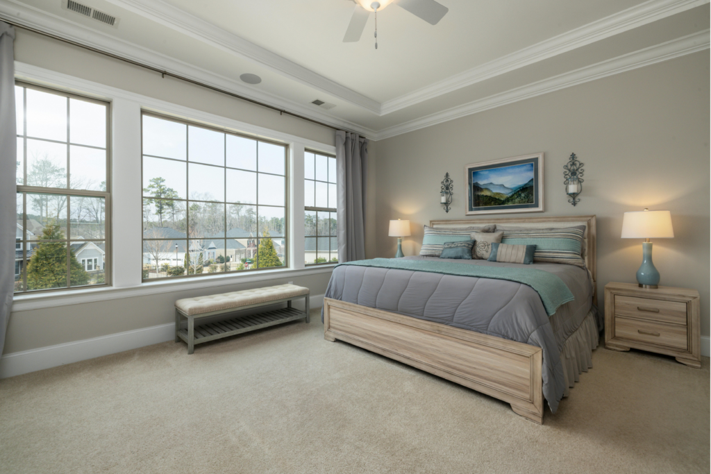 Spacious bedroom with two double-hung windows flanking a large center picture window, illustrating a window combination that meets bedroom egress requirements