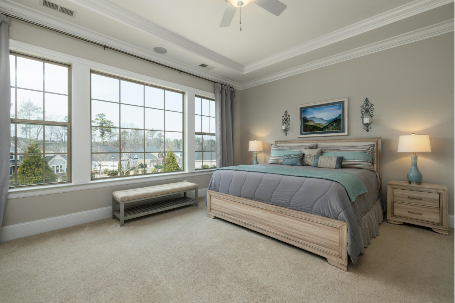 Spacious bedroom with two double-hung windows flanking a large center picture window, illustrating a window combination that meets bedroom egress requirements
