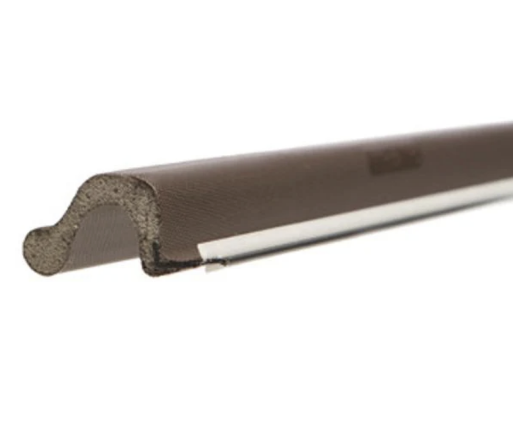 Close-up of kerf weatherstripping showing the foam sealing bulb and the stiff fin that presses into the kerf slot.